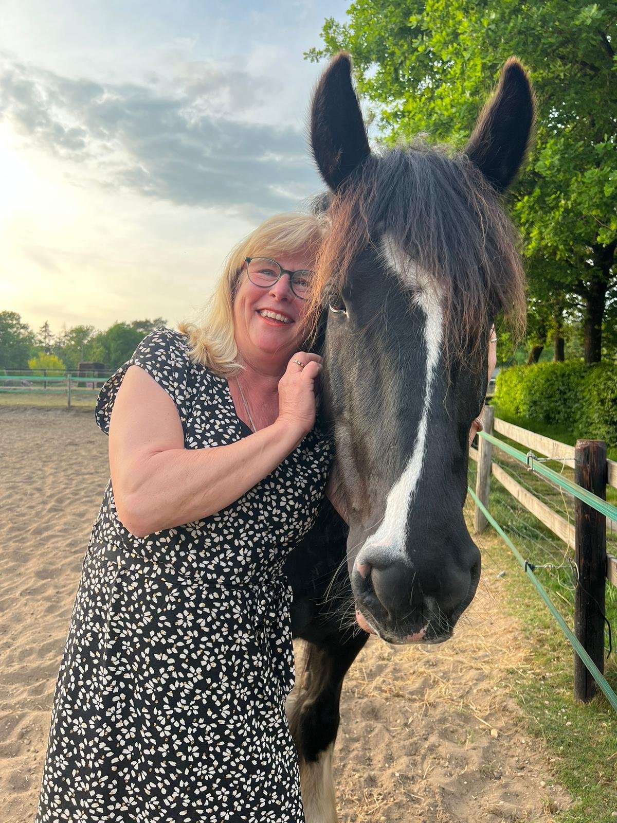 Janneke lacht naast haar paard Caressa
